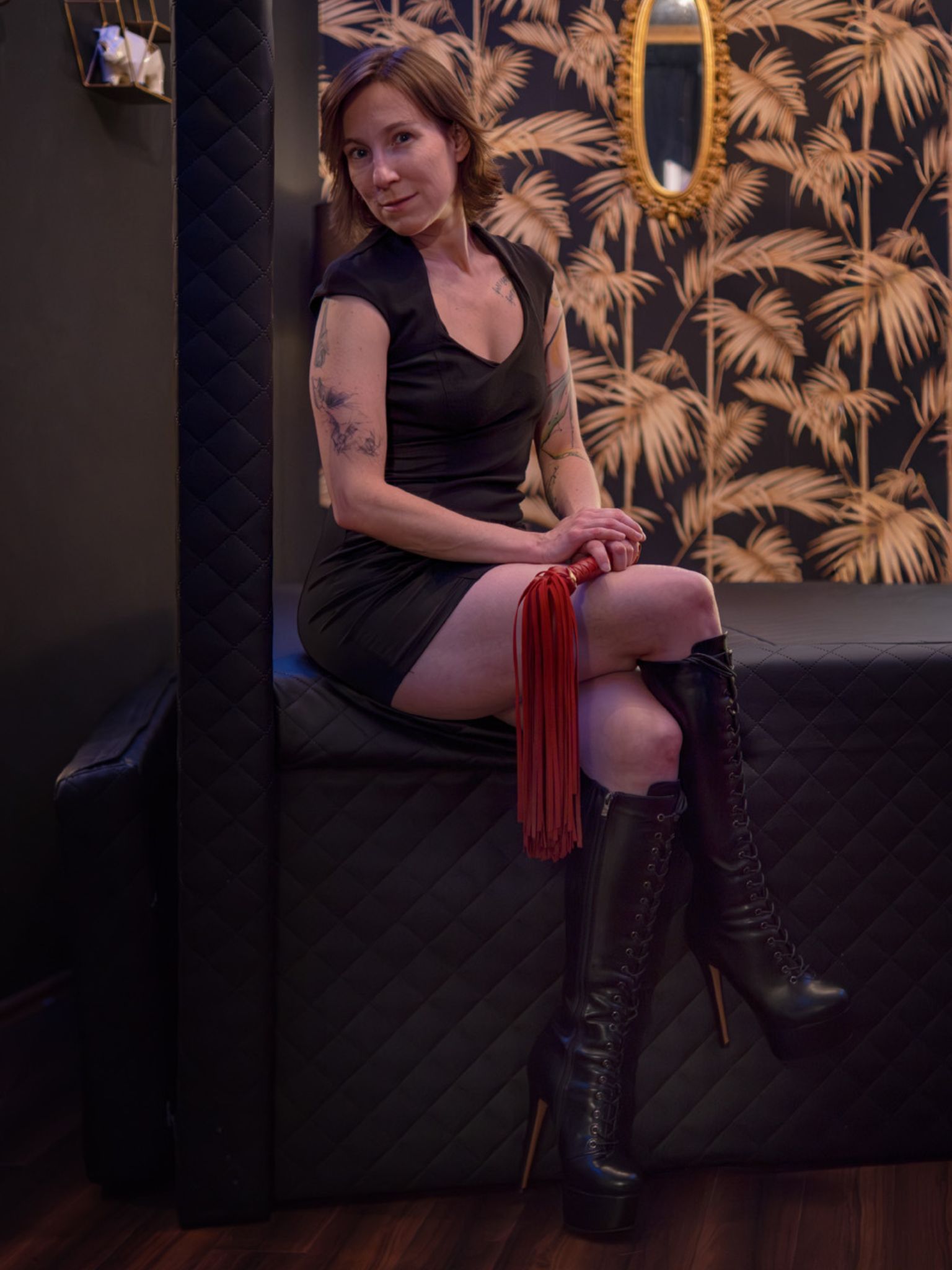 Refugium Divine Jay Stark Peitsche Jay Stark in schwarzem Kleid mit Peitsche