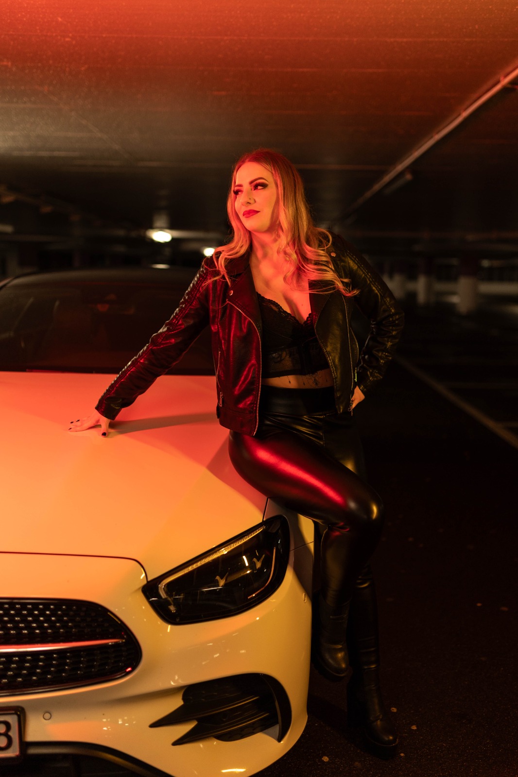 Electra Pure Divine auf Auto in Tiefgarage Electra Pure Divine in schwarzem Outfit in einer Tiefgarage