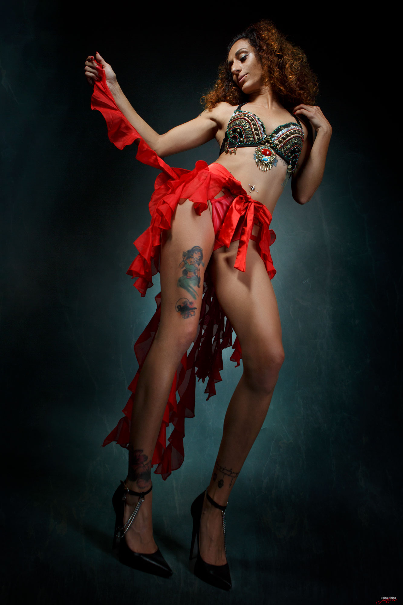 Lady Sam in reizvollem BH und rotem Rock, orientalischer Vibe.